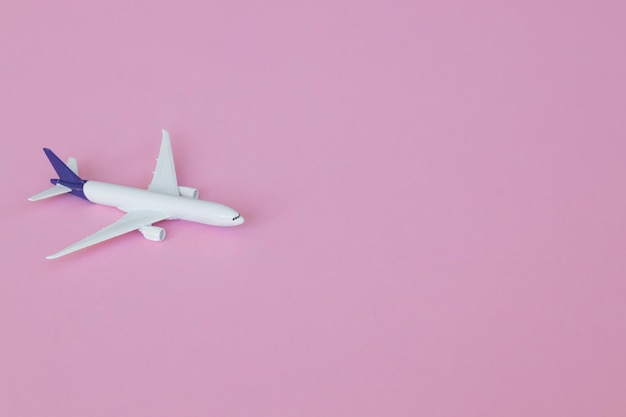 Conceito de viagem em fundo rosa com espaço de cópia brinquedo de avião em fundo de cor rosa