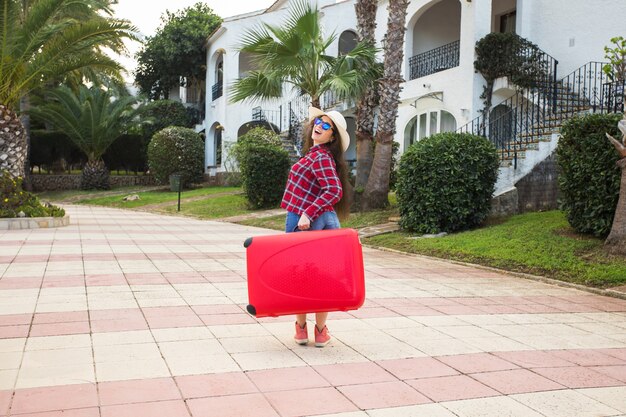 Conceito de viagem, férias, férias, viagem e pessoas. turista de mulher com mala aparecendo o polegar quando chegou no hotel.