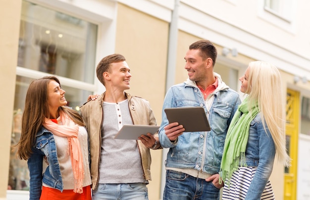 conceito de viagem, férias, tecnologia e amizade - grupo de amigos sorridentes com computadores tablet pc na cidade