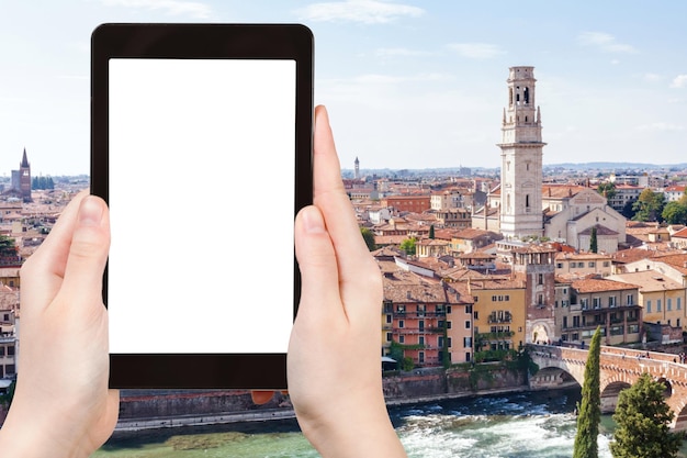 conceito de viagem - turista fotografa a cidade de Verona em tablet com tela cortada com lugar em branco para publicidade na Itália