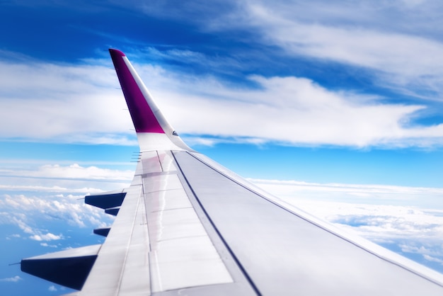 Conceito de viagens. Asa de avião voando acima das nuvens no céu. Espaço da cópia