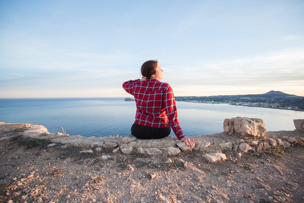 Conceito de viagens, aventuras e natureza - Mulheres turistas sentadas sozinhas na montanha