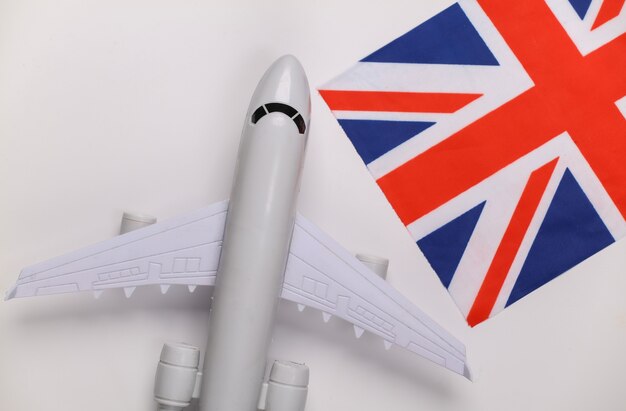 Conceito de viagens. Avião de passageiros e bandeira britânica em fundo branco