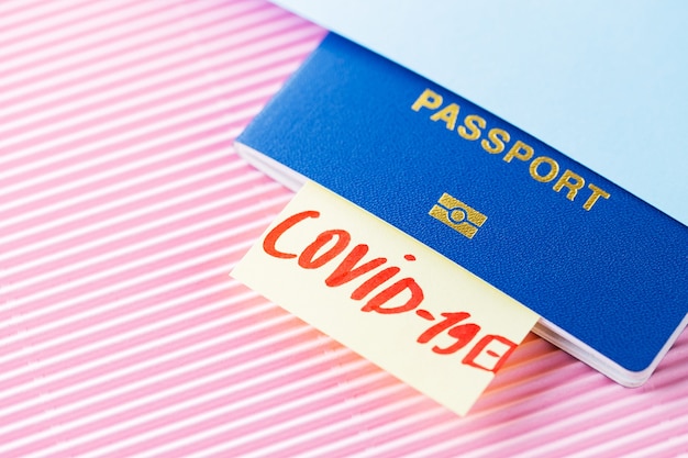 Conceito de viagens e bloqueio. Viajando em período epidêmico. Teste de passaporte e coronavírus em fundo azul rosa. Exame médico no aeroporto