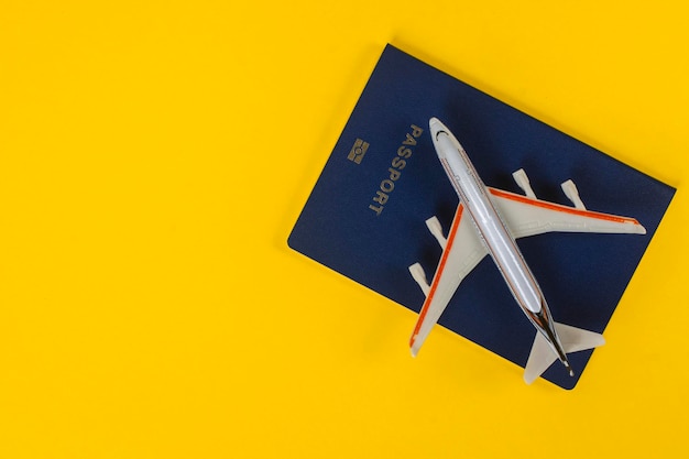 Conceito de viagens. Passaporte e modelo de avião em um fundo amarelo.