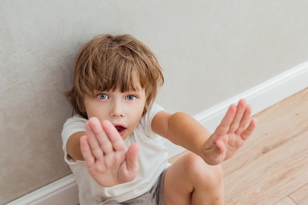 Conceito de violência doméstica e abuso infantil. Garotinho mostrando o gesto STOP com a mão