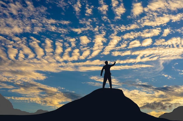 Foto conceito de vitória, a silhueta de um homem de pé no céu do sol.