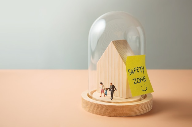 Conceito de zona de segurança, amor e cuidado. Figura miniatura de família caminhando dentro de uma cúpula de vidro