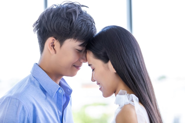 Conceito do dia dos namorados, retrato de asiático Jovem casal feliz cara a cara beijando no fundo de casa, espaço de cópia, casal de histórias de amor