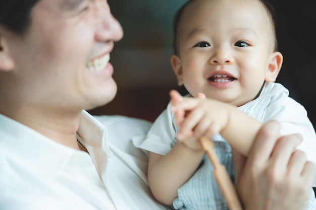 Conceito do Dia dos Pais jovem pai asiático segurando um filho bebê com pessoa da família em casa infância feliz com amor e carinho juntos filho bonito com pai e pai paternidade estilo de vida