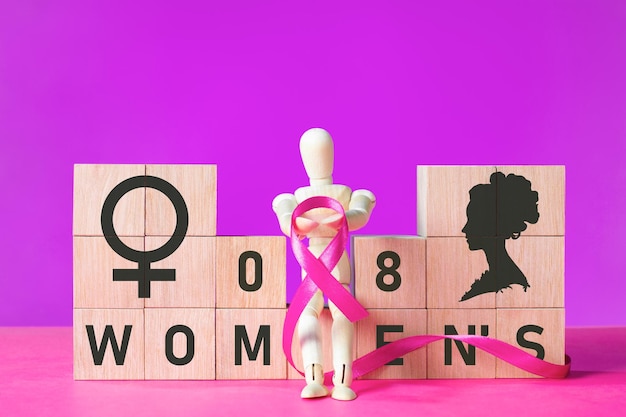 Conceito do Dia Internacional da Mulher com blocos de madeira e boneca segurando uma fita roxa