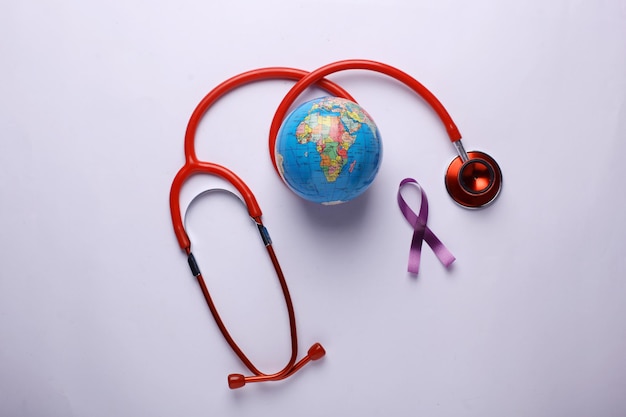 Conceito do Dia Mundial do Câncer Fita roxa com globo e estetoscópio