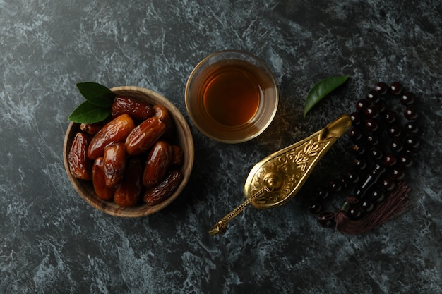 Conceito do Ramadã com comida e acessórios em uma superfície preta esfumada