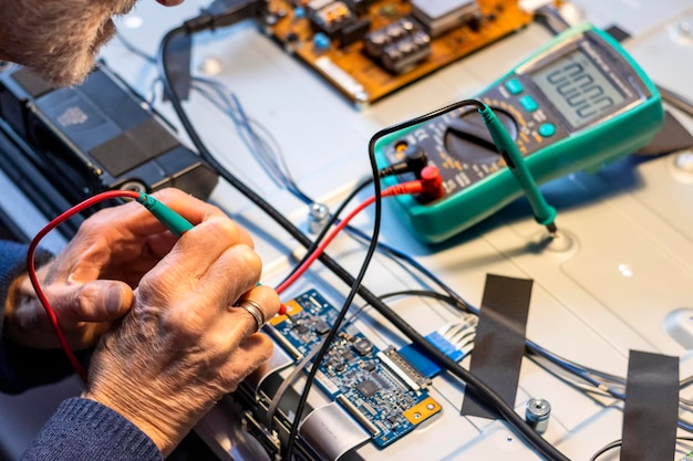 Foto conceito eletrônico mãos de um homem idoso com um testador medindo tensões