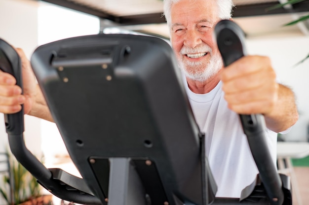 Conceito esportivo de pessoas Retrato de um idoso feliz andando de bicicleta fazendo exercícios andando de bicicleta ergométrica