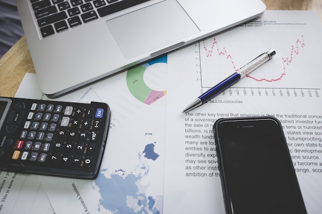 Foto conceito financeiro de negócios laptop, caneta, café, smartphone, gráfico para finanças