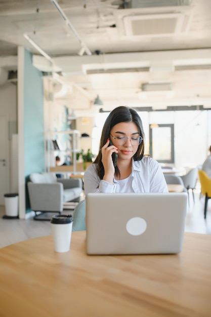 Conceito freelance de negócios e comércio eletrônico Jornalista feminina entusiasmada criativa escrevendo um novo artigo digitando no laptop sorrindo idéias de projeto de anotação sentar café beber café trabalhando remotamente