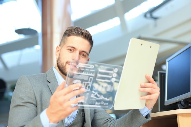 Foto conceito futuro. empresário analisando estatísticas financeiras exibidas na tela do tablet transparente futurista.