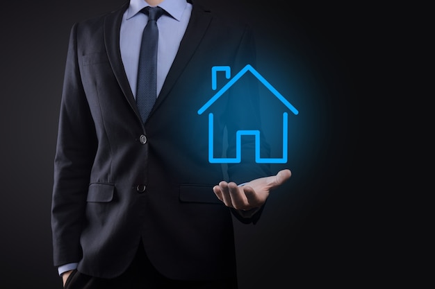 Conceito imobiliário, empresário segurando um ícone de casa. Casa disponível. Conceito de seguro e segurança de propriedade. Protegendo o gesto do homem e o símbolo da casa.