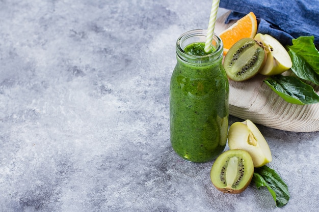 Conceito limpo da bebida do vegetariano comer da desintoxicação. Smoothies verdes frescos com frutas no fundo da tabela