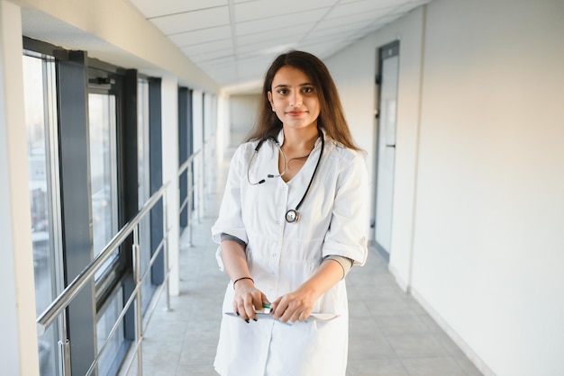 Conceito médico da bela médica indiana de jaleco branco com estetoscópio, cintura para cima. estudante de medicina.