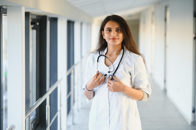 Conceito médico da bela médica indiana de jaleco branco com estetoscópio, cintura para cima. Estudante de medicina.