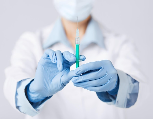 conceito médico e de saúde - close-up de uma médica segurando uma seringa com injeção