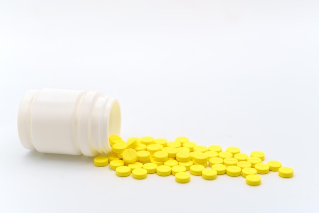 Conceito médico e de saúde Closeup de pílulas amarelas com garrafa em fundo branco