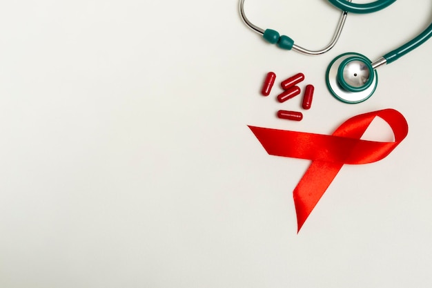 Foto conceito médico para o dia mundial de aids de dezembro fita vermelha estetoscópio médico verde e terapia pil