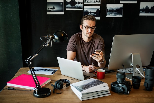 Conceito ocupado do escritório domiciliário da edição do fotógrafo do homem