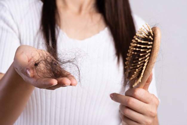 Foto conceito saudável. a mulher mostra sua escova com cabelo danificado da perda longa