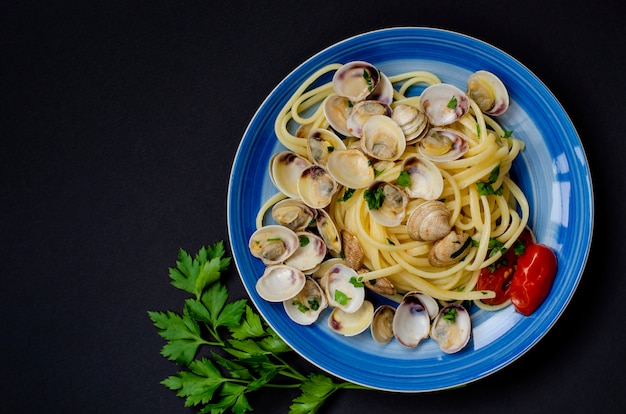 Conceito tradicional de frutos do mar italiano. Espaguete com amêijoas ou prateleira, tomate e ervas