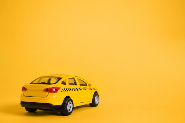 Foto conceito urbano de serviço de táxi e entrega. modelo de carro de táxi amarelo de brinquedo