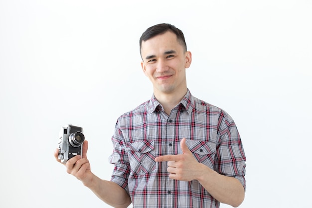 Conceito vintage, fotógrafo e pessoas - homem bonito com câmera retro sobre fundo branco com espaço de cópia.