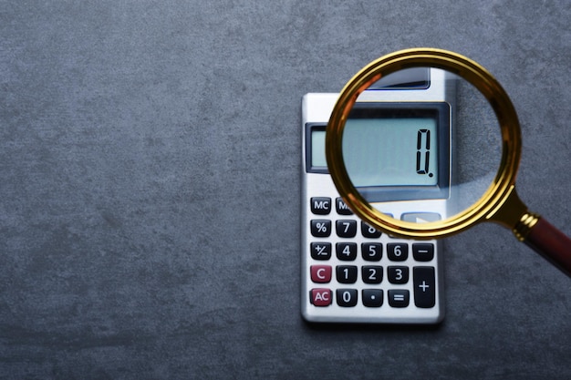 Conceitos financeiros, uma calculadora mostrando zero com lupa