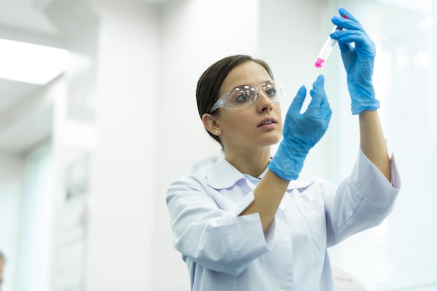 Concentrado jovem pesquisador levantando as mãos ao fazer perícia química no laboratório