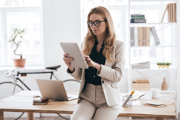 concentrado no trabalho. jovem confiante em roupa casual inteligente trabalhando em tablet digital