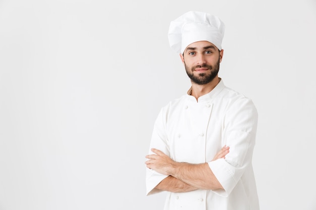 concentrado positivo jovem chef posando de uniforme.