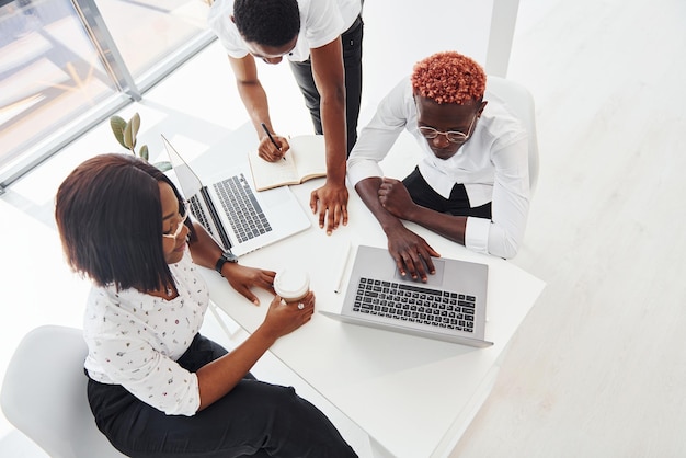 Concentrado en el proyecto mediante el uso de una computadora portátil Grupo de empresarios afroamericanos que trabajan juntos en la oficina