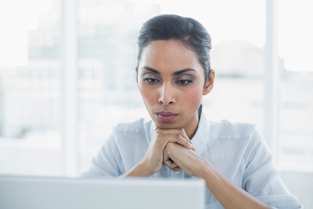 Concentrando a empresaria sentada en su escritorio