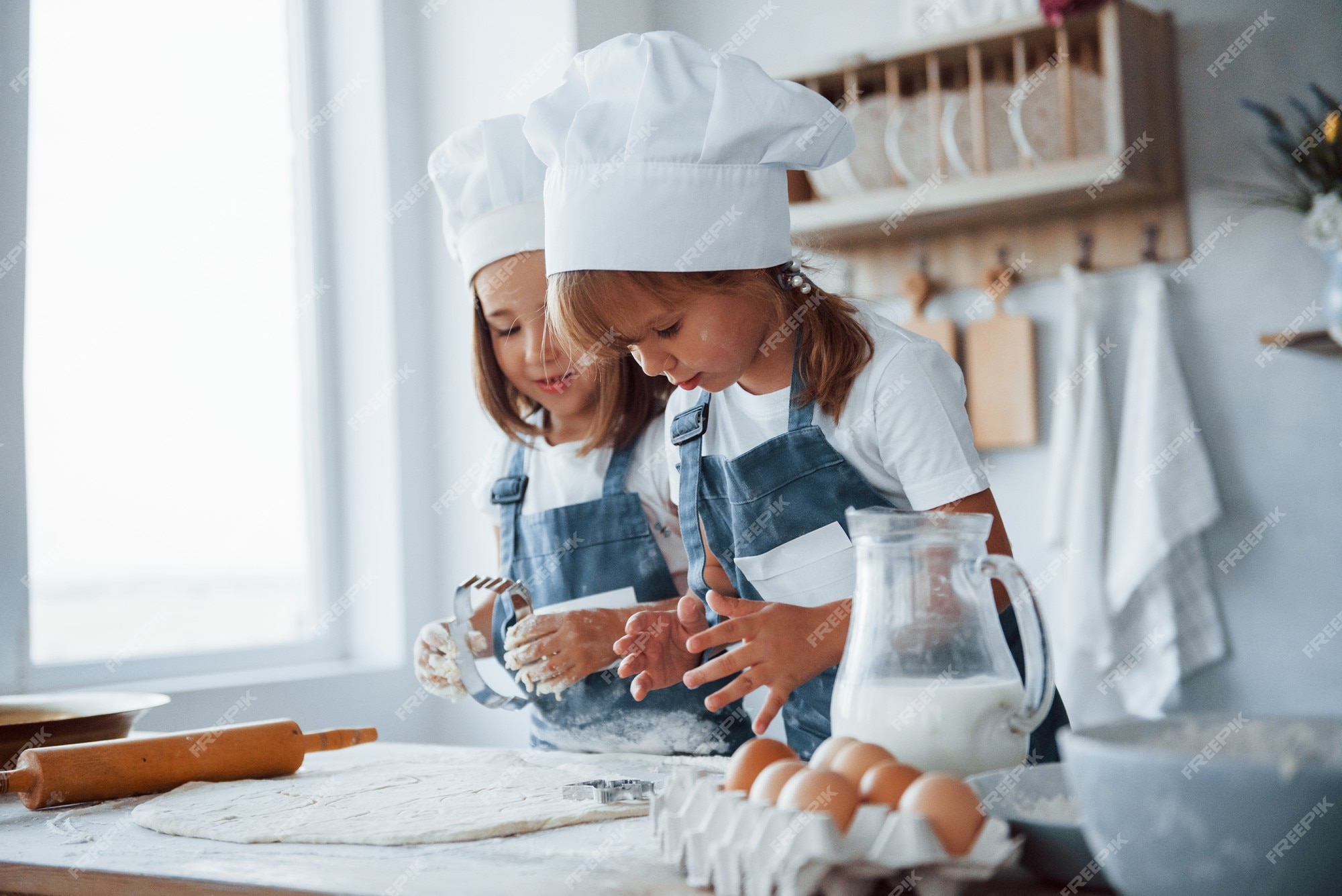 Concentrarse en cocinar. niños de la familia en uniforme chef blanco preparando la comida en la cocina. | Foto Premium