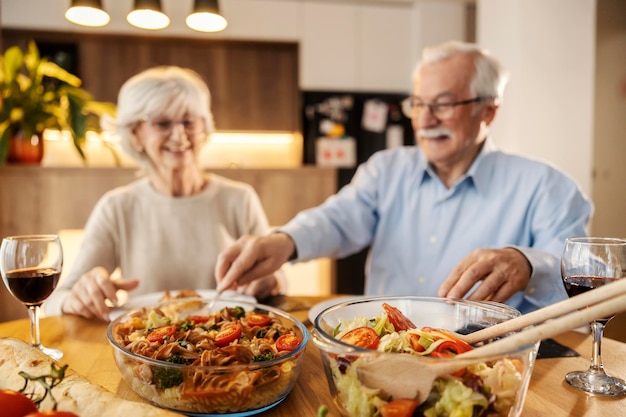 Concentrarse selectivamente en un almuerzo con una pareja de mayores en un fondo borroso