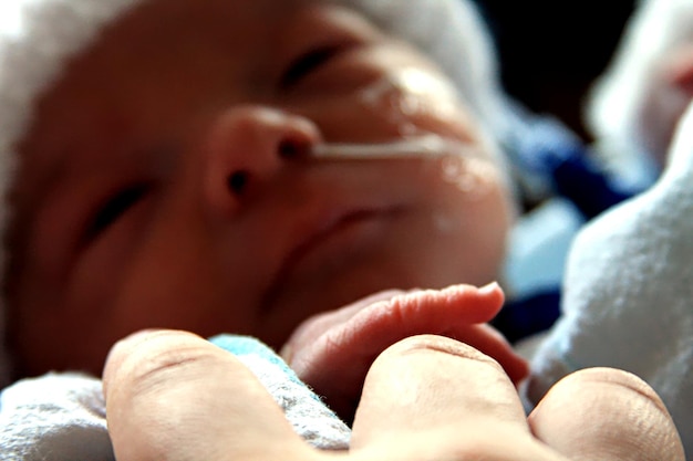 Foto concéntrate en el recién nacido sosteniendo el dedo de la madre