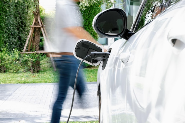 Concentre-se carregando o carro EV com fundo desfocado do homem parado no EV progressivo