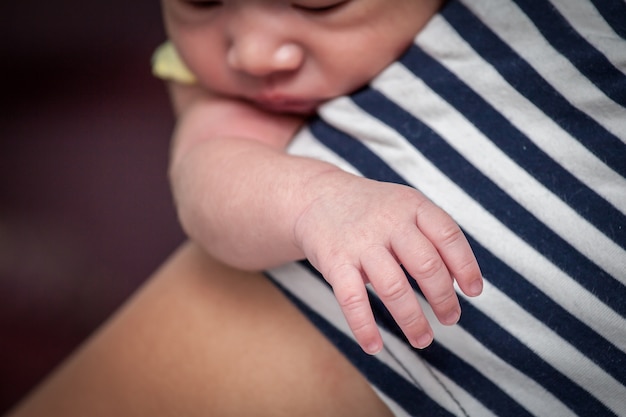 Foto concentre-se na mão recém-nascida do bebê no ombro da mãe