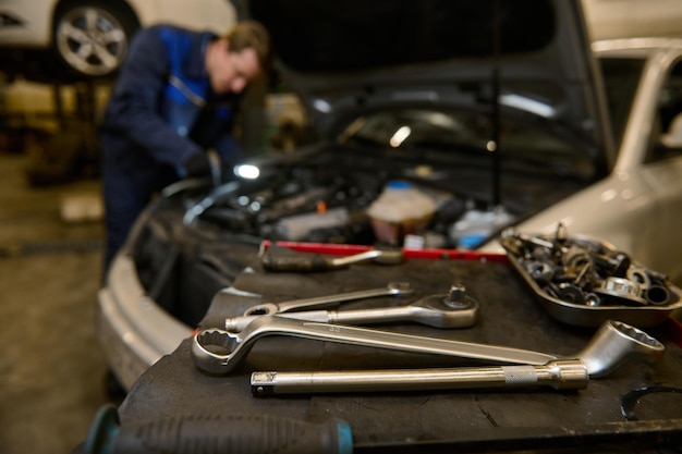 Concéntrese en la llave inglesa y las herramientas profesionales para reparar e inspeccionar automóviles sobre un escritorio