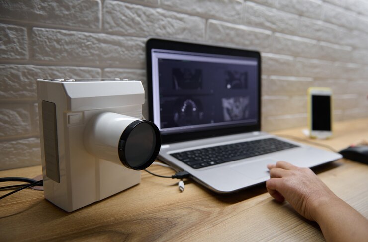 Foto concéntrese en la moderna máquina de rayos x portátil profesional utilizada en odontología en el fondo de la mano del médico en el teclado de la computadora portátil con radiografía panorámica dental en el monitor de pantalla que brinda una consulta en línea