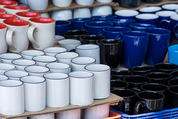 Concéntrese en el primer plano de muchas tazas de cerámica que se exhiben a la venta en el mercado al aire libre