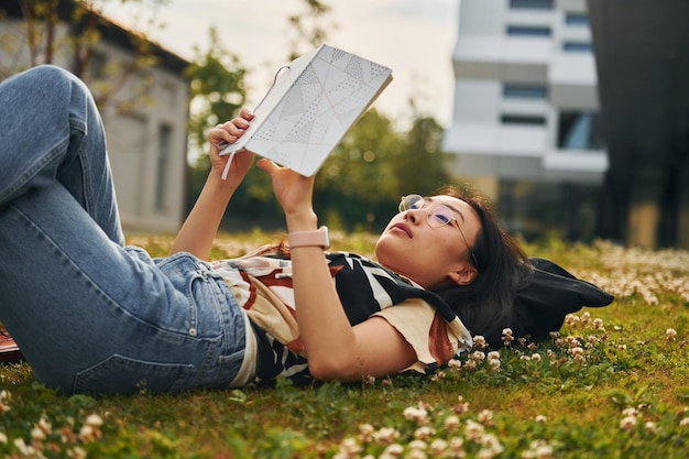 Concepção de educação A jovem asiática está ao ar livre durante o dia