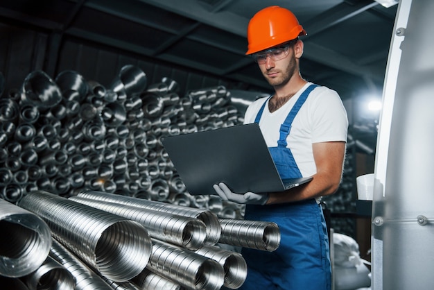 Concepção de fabricação. homem de uniforme trabalha na produção. tecnologia industrial moderna.